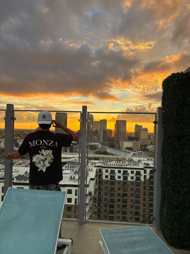 Zach on a rooftop looking out over the city at sunset
